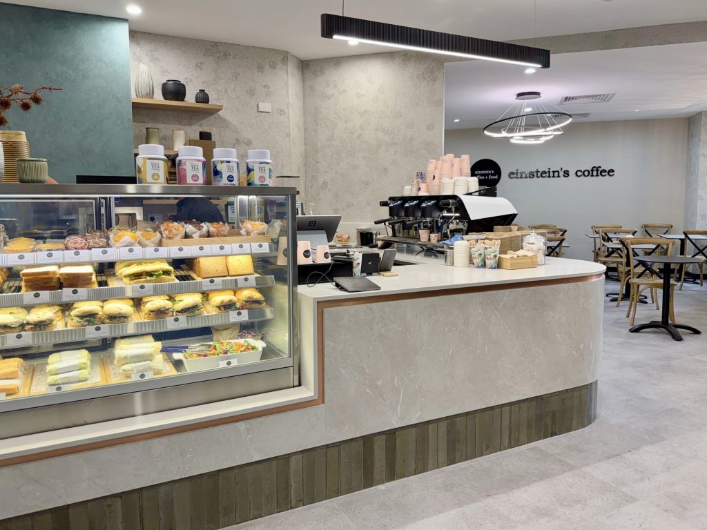 Contemporary cafe fitout with blue feature walls and rose gold cabinetry detailing