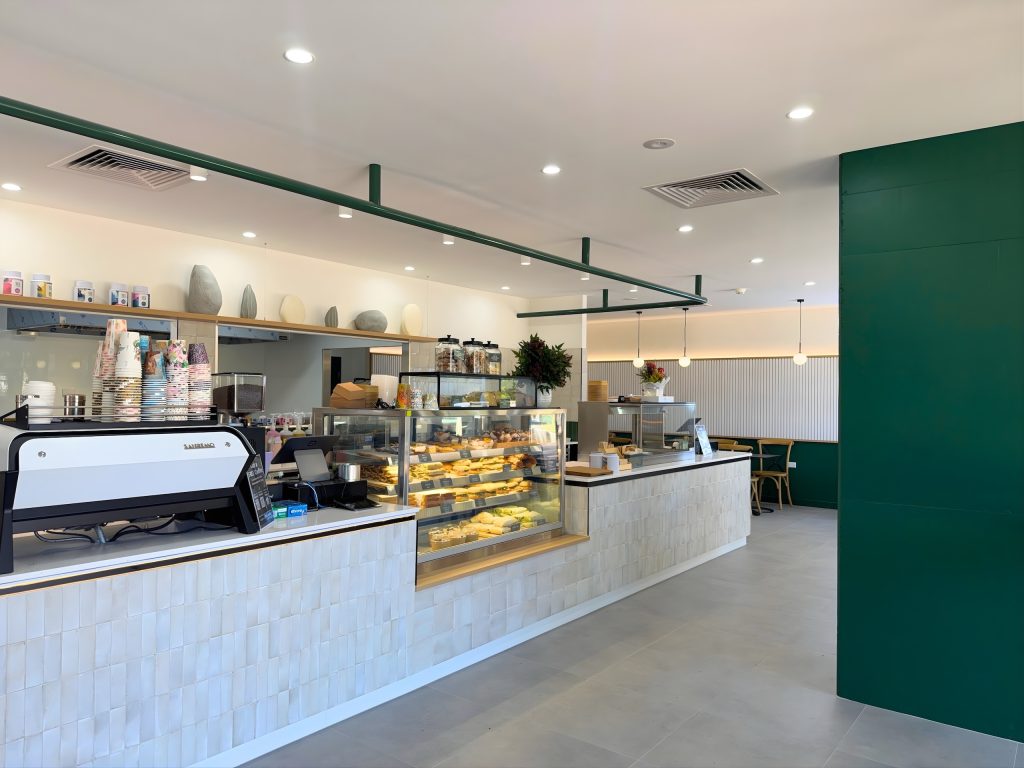 Cafe fitout featuring custom joinery, display cabinets and green accents